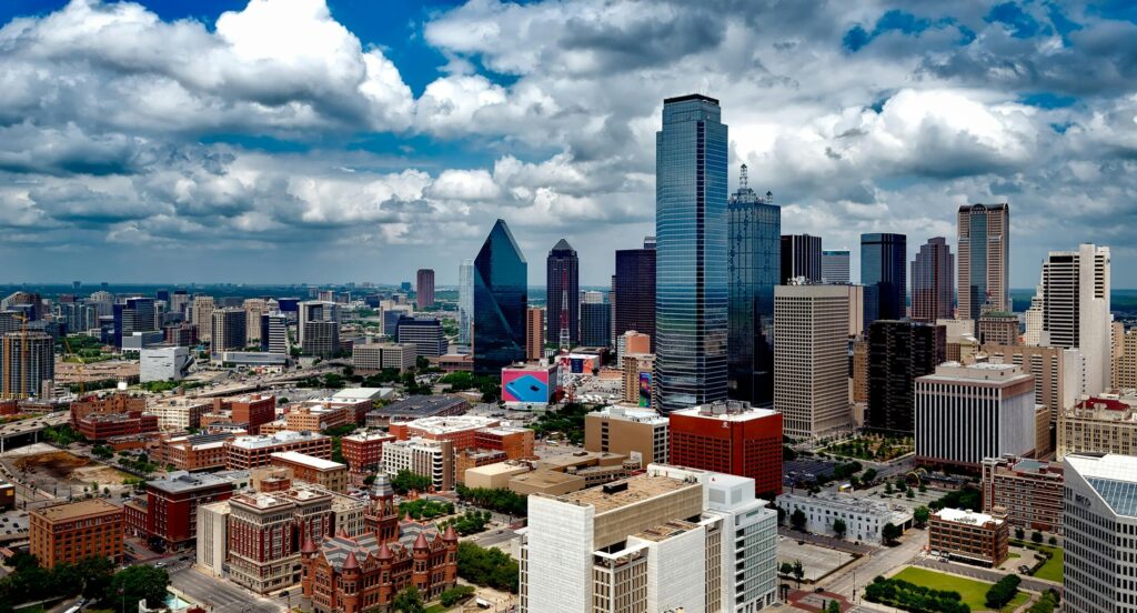 Renting a KNEE SCOOTER is Cheaper than Buying in Dallas, Texas. Downtown Dallas, Texas aerial shot under clouds